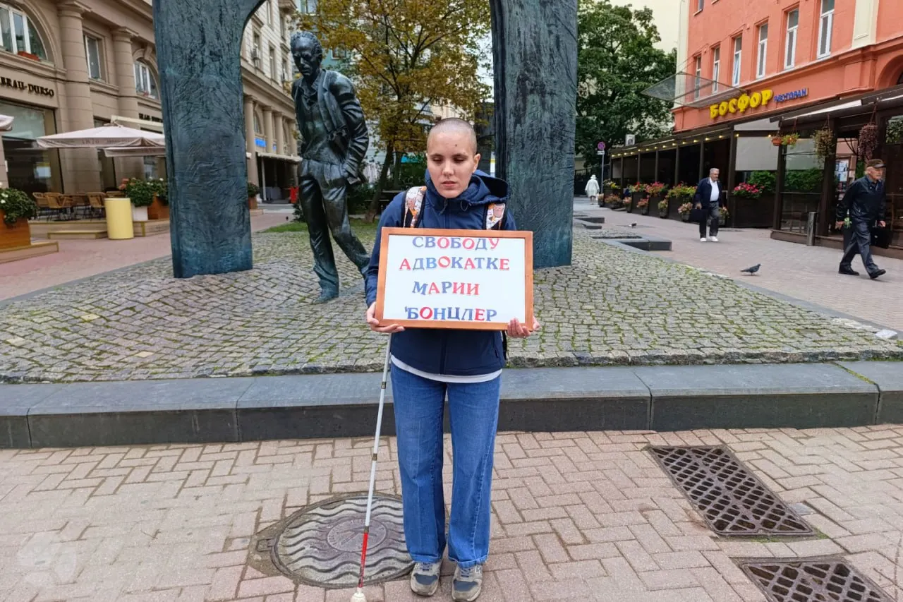 Незрячая активистка Оксана Осадчая вышла на пикет в центре Москвы с призывом освободить Марии Бонцлер, задержанную по делу о госизмене; здоровье адвокатки вызывает тревогу.